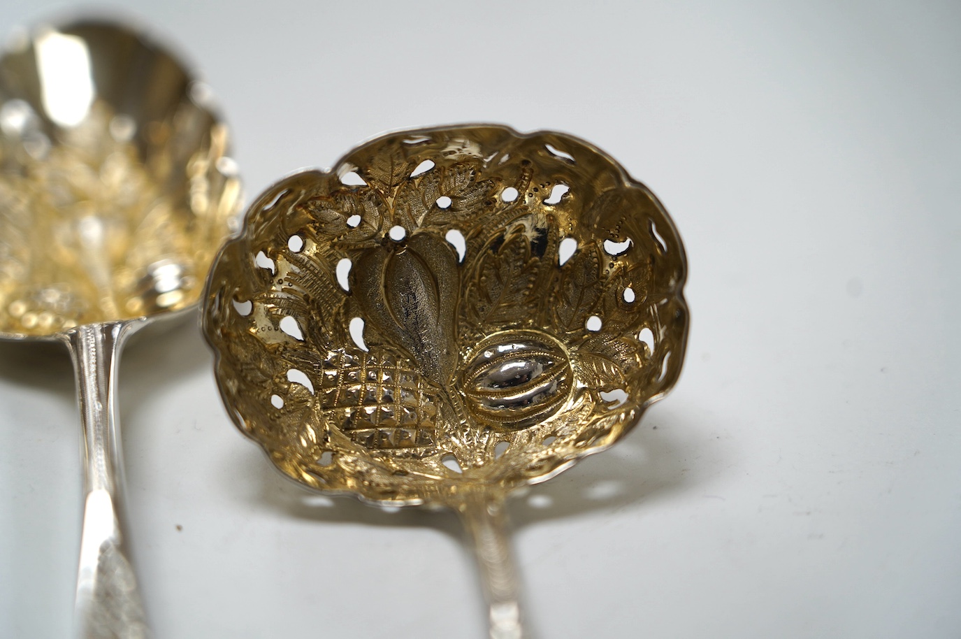 A pair of George III silver berry spoons, London, 1804, together with three other spoons, including a Georgian Scottish table spoon and a George III silver berry sifter spoon, Eley, Fearn & Chawner, London, 1809, 10.6oz.